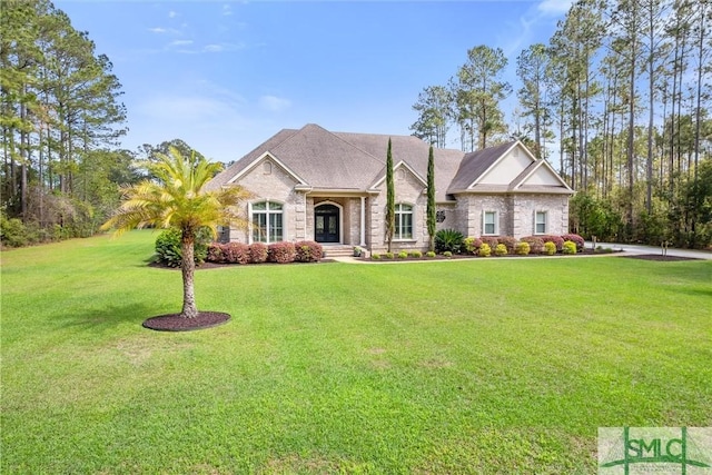 view of front of house with a front yard and brick siding