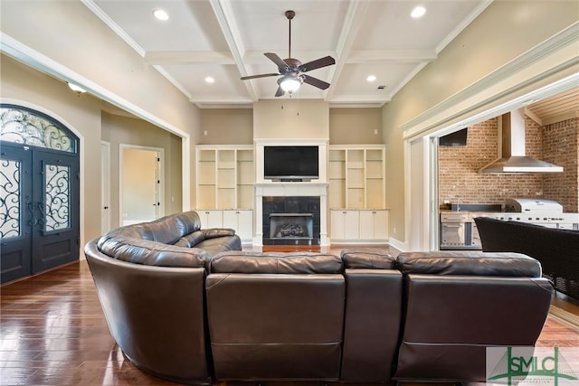 living room with beamed ceiling, a ceiling fan, ornamental molding, wood finished floors, and coffered ceiling