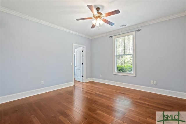 spare room featuring visible vents, baseboards, crown molding, and wood finished floors