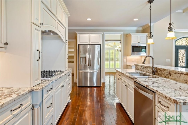 kitchen with dark wood-style floors, a sink, ornamental molding, and appliances with stainless steel finishes