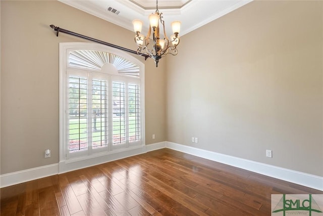 spare room with a chandelier, ornamental molding, dark wood finished floors, and visible vents