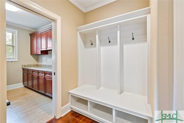 mudroom with baseboards, ornamental molding, and wood finished floors