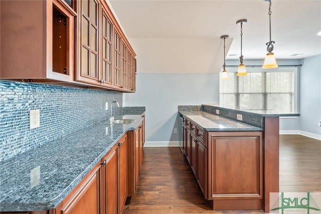 kitchen featuring dark wood-type flooring, brown cabinets, and dark stone counters