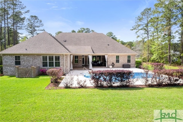 rear view of house with an outdoor pool, a patio area, brick siding, central AC unit, and a lawn