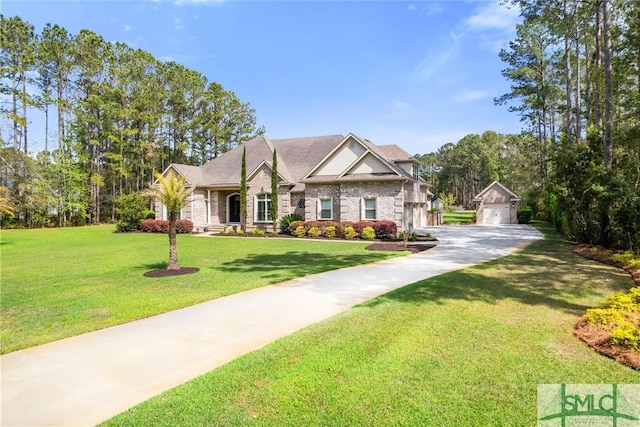 view of front of home with a garage, a front yard, and an outdoor structure
