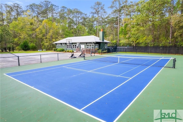 view of tennis court featuring fence and community basketball court