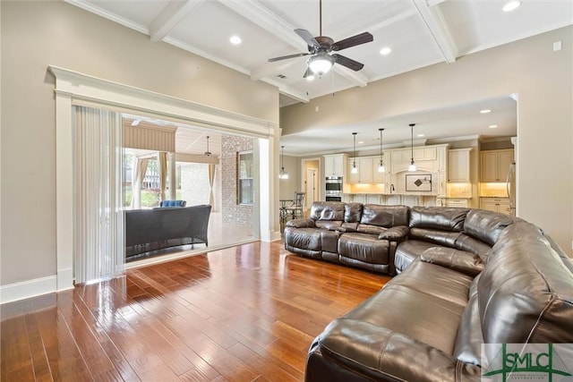 living room featuring crown molding, beamed ceiling, ceiling fan, and hardwood / wood-style flooring