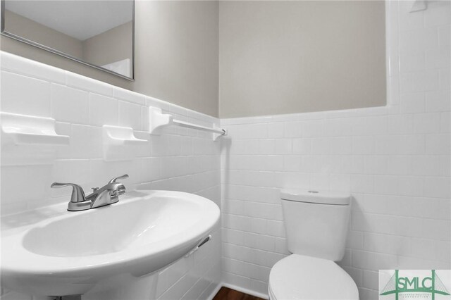 1517 E 52nd St, Savannah, GA 31404 - half bath with a sink, toilet, tile walls, and wainscoting