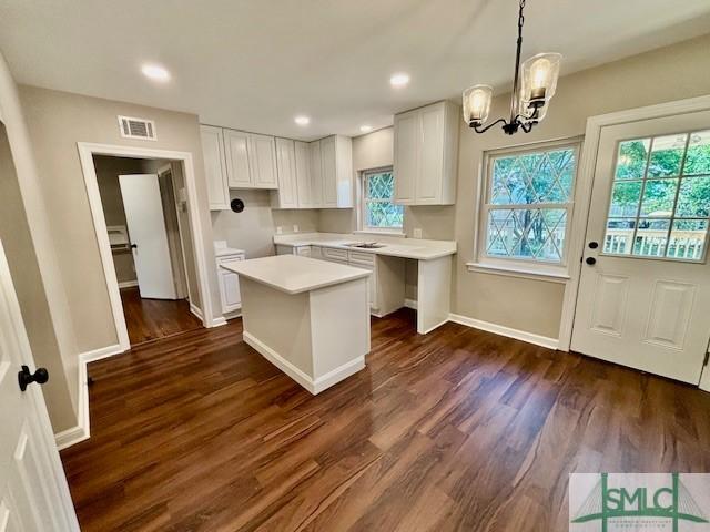 1517 E 52nd St, Savannah, GA 31404 - kitchen featuring dark wood-style flooring, white cabinetry, a chandelier, a center island, and light countertops