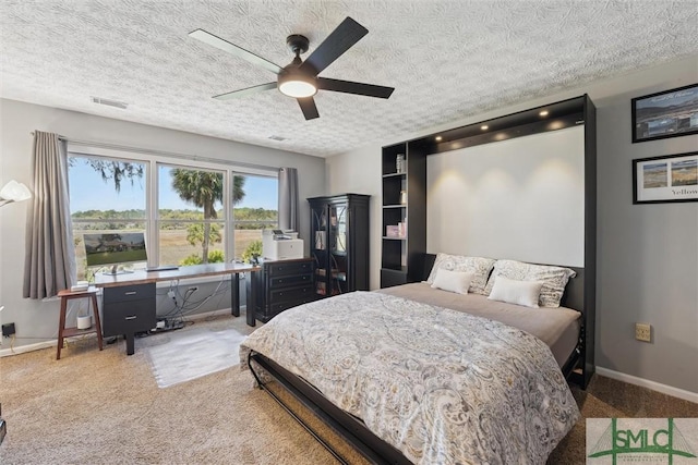 bedroom featuring a textured ceiling, visible vents, baseboards, ceiling fan, and carpet floors