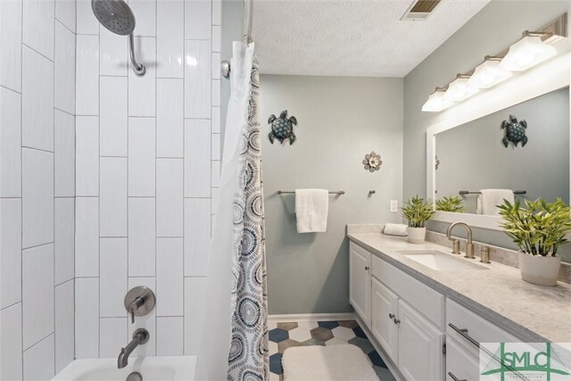 full bath with shower / tub combo with curtain, vanity, a textured ceiling, baseboards, and visible vents