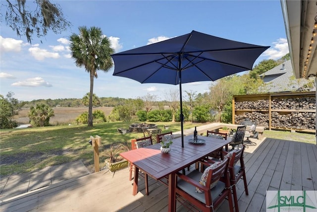 deck featuring a lawn, outdoor dining area, and an outdoor fire pit