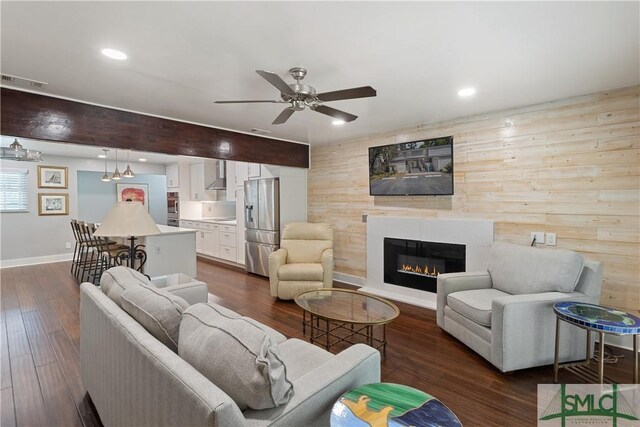 1000 Sea Island Rd Unit 56, Saint Simons Island, GA 31522 - living room featuring ceiling fan, a glass covered fireplace, dark wood-type flooring, recessed lighting, and wooden walls