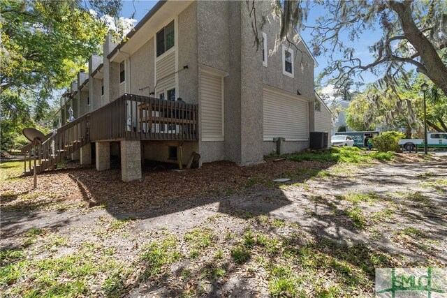 1000 Sea Island Rd Unit 56, Saint Simons Island, GA 31522 - view of home's exterior featuring stairs, a deck, and stucco siding
