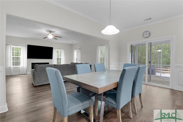 dining space featuring ornamental molding, visible vents, a healthy amount of sunlight, and light wood finished floors
