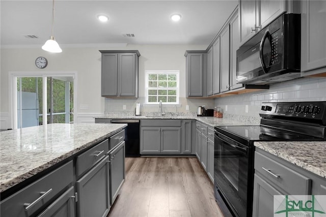 kitchen featuring crown molding, gray cabinetry, a sink, visible vents, and black appliances