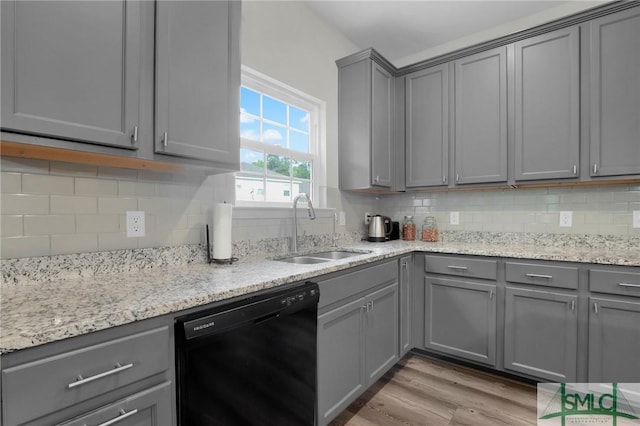 kitchen with dishwasher, gray cabinets, a sink, and light wood finished floors