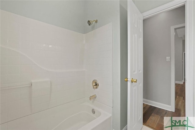 bathroom featuring bathing tub / shower combination, wood finished floors, and baseboards