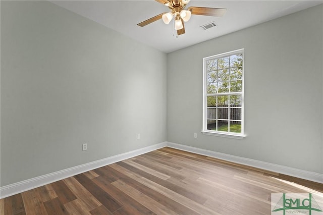 unfurnished room with wood finished floors, ceiling fan, baseboards, and visible vents