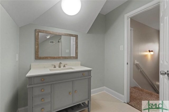 bathroom with visible vents, baseboards, vanity, and lofted ceiling