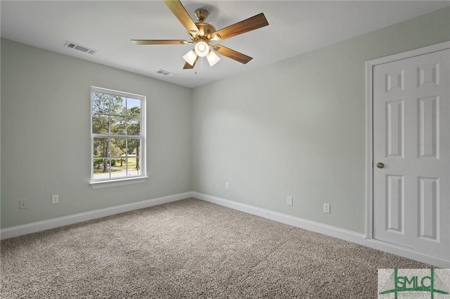 carpeted spare room with ceiling fan, baseboards, and visible vents