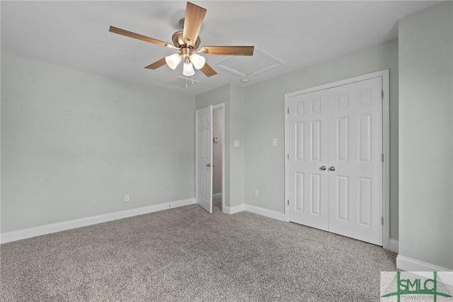 unfurnished bedroom with a closet, a ceiling fan, attic access, and carpet