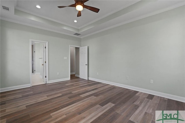 unfurnished bedroom with crown molding, visible vents, a raised ceiling, and dark wood finished floors