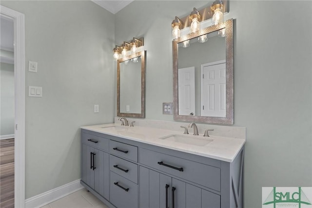 full bath featuring a sink, tile patterned floors, baseboards, and double vanity