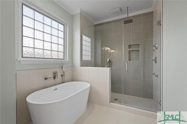 bathroom featuring a shower stall, crown molding, and a soaking tub