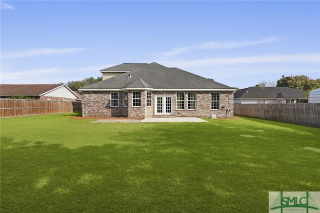 back of property with a yard, french doors, and a fenced backyard