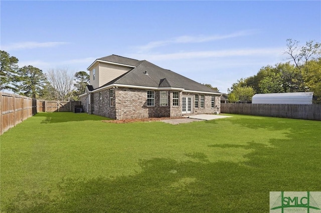 rear view of house with a yard, a patio area, a fenced backyard, and brick siding