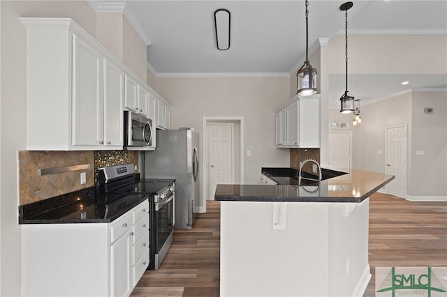 kitchen with white cabinetry, appliances with stainless steel finishes, wood finished floors, and ornamental molding