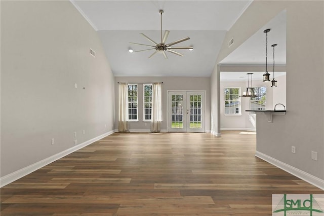 unfurnished living room with french doors, baseboards, plenty of natural light, and ceiling fan with notable chandelier