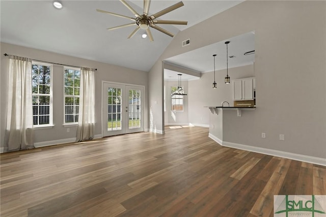unfurnished living room with baseboards, a ceiling fan, visible vents, high vaulted ceiling, and wood finished floors