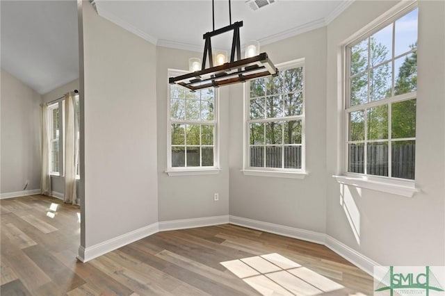 unfurnished dining area featuring crown molding, visible vents, a chandelier, wood finished floors, and baseboards