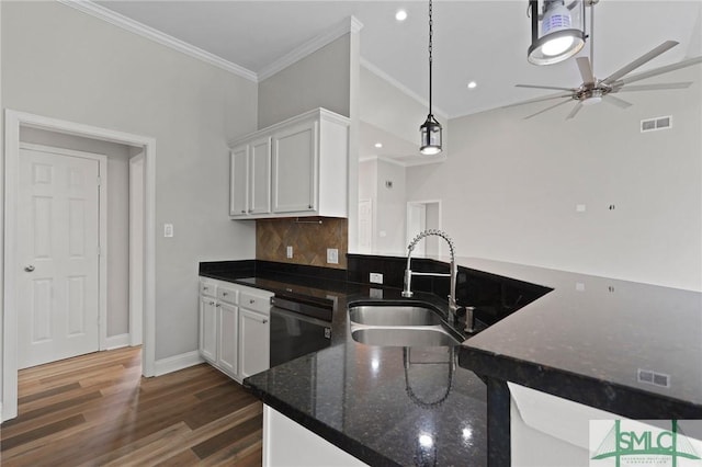 kitchen with ceiling fan, ornamental molding, white cabinets, black dishwasher, and a sink