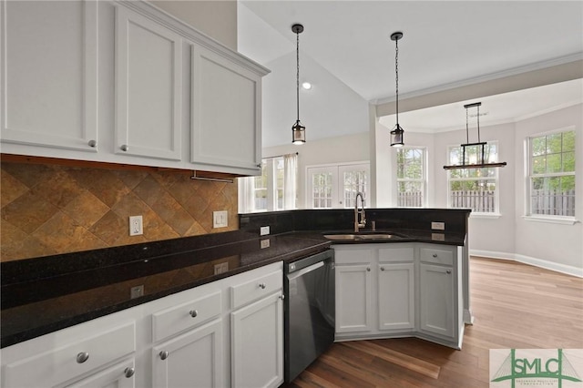 kitchen with dishwasher, a sink, a peninsula, wood finished floors, and backsplash