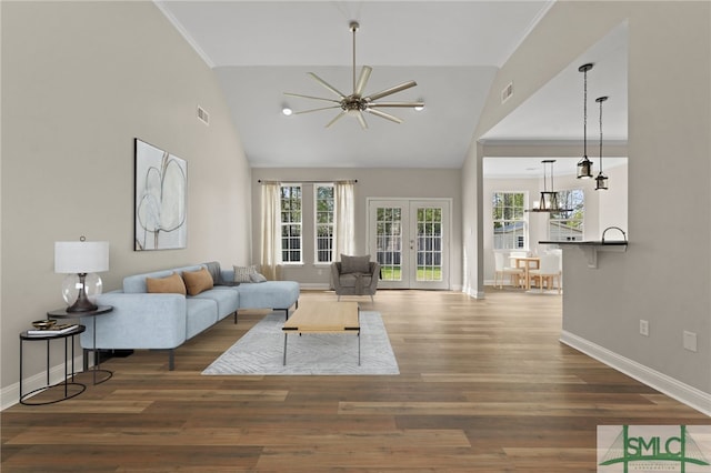 living area with plenty of natural light, ceiling fan with notable chandelier, and baseboards