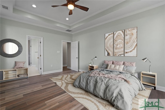 bedroom featuring visible vents, a raised ceiling, crown molding, recessed lighting, and wood finished floors