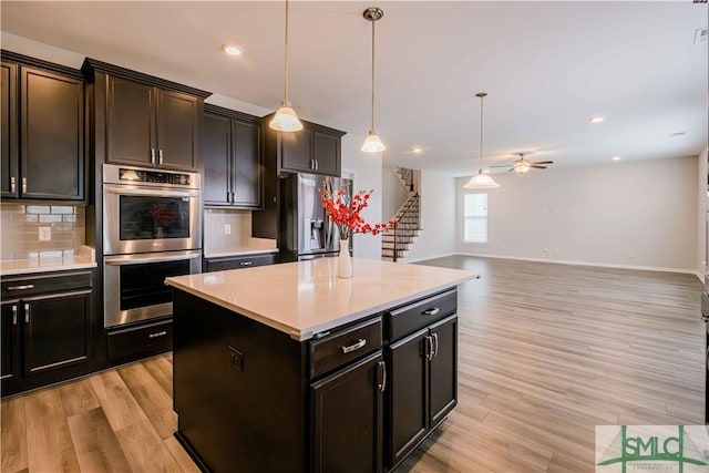 135 Sessile Oak Dr, Savannah, GA 31419 - kitchen with light wood-type flooring, a ceiling fan, appliances with stainless steel finishes, and decorative backsplash