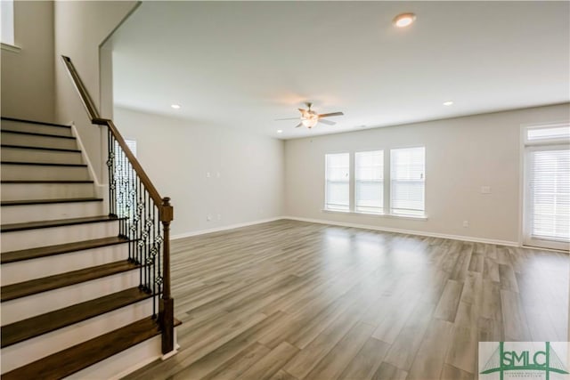135 Sessile Oak Dr, Savannah, GA 31419 - unfurnished living room featuring light wood-style flooring, stairway, a ceiling fan, and plenty of natural light