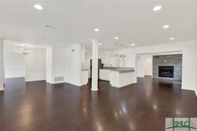 13 Burnt Tree Rd, Savannah, GA 31419 - unfurnished living room with a fireplace, dark wood-type flooring, recessed lighting, a wainscoted wall, and a chandelier