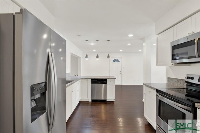 13 Burnt Tree Rd, Savannah, GA 31419 - kitchen with stainless steel appliances, dark wood-type flooring, white cabinets, a peninsula, and decorative light fixtures