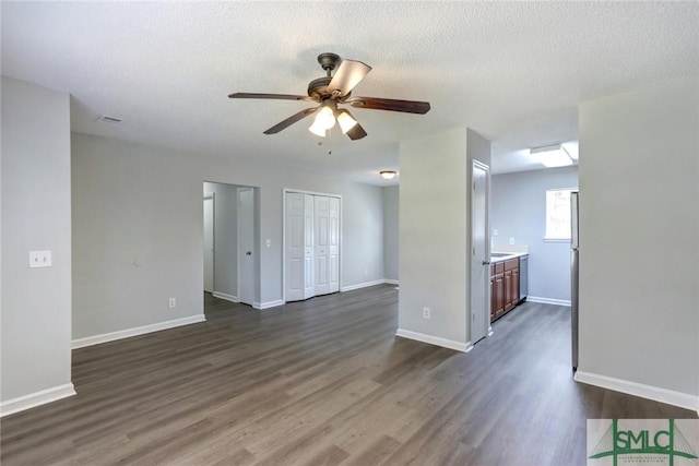 unfurnished room with dark wood-style floors, baseboards, and a ceiling fan