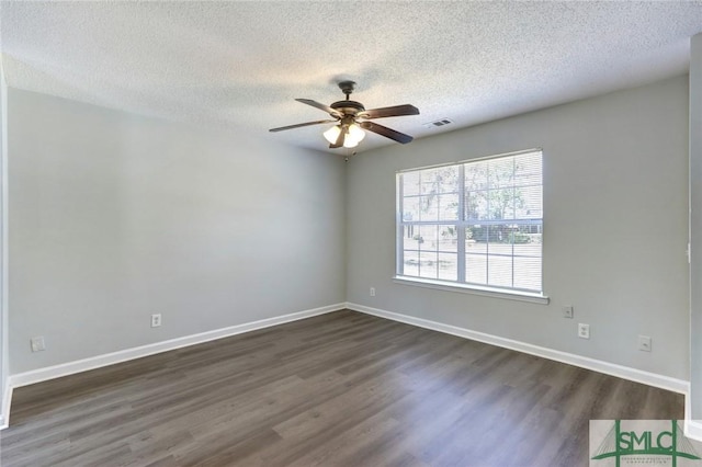 empty room featuring baseboards, dark wood-style flooring, ceiling fan, and a textured ceiling