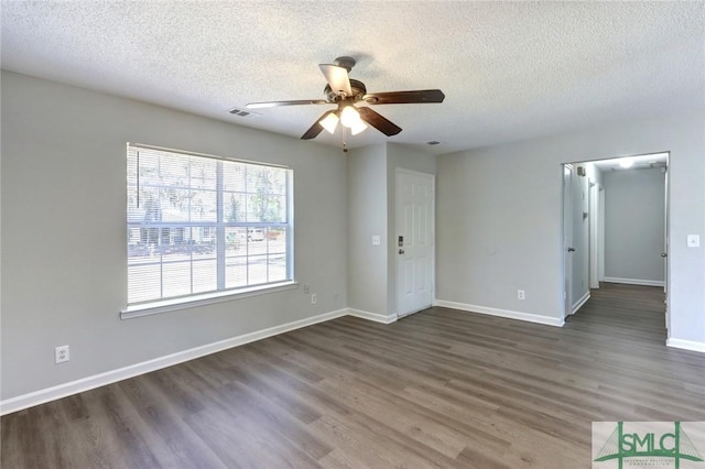 unfurnished room with baseboards, visible vents, wood finished floors, and a ceiling fan