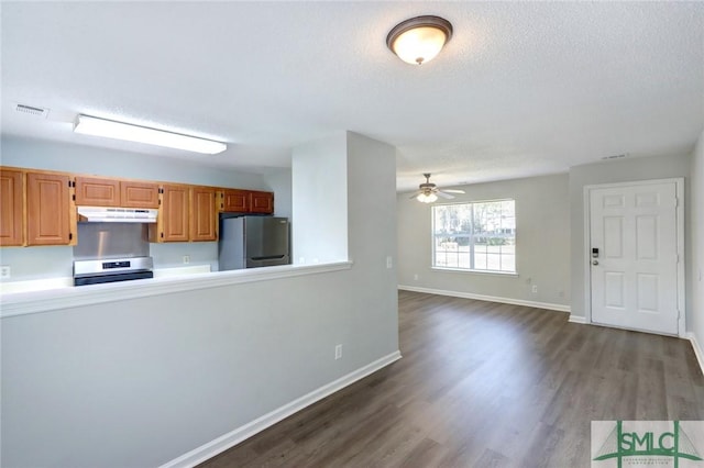 kitchen featuring appliances with stainless steel finishes, under cabinet range hood, visible vents, ceiling fan, and dark wood-type flooring