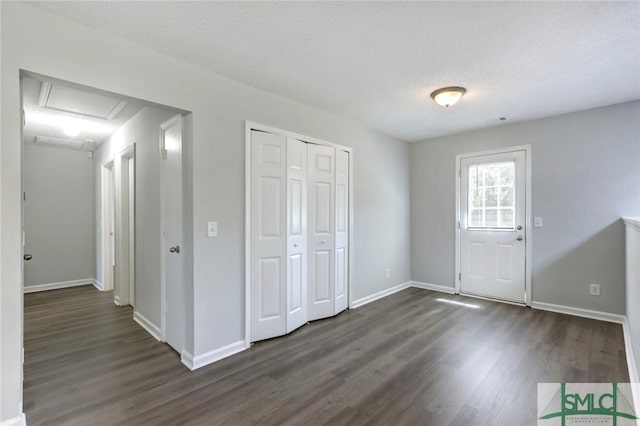 foyer featuring dark wood-style floors, baseboards, and a textured ceiling