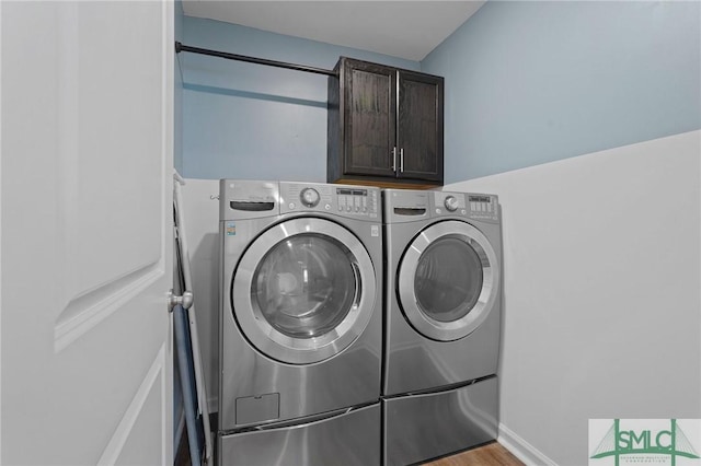 laundry area featuring cabinet space, independent washer and dryer, and light wood finished floors