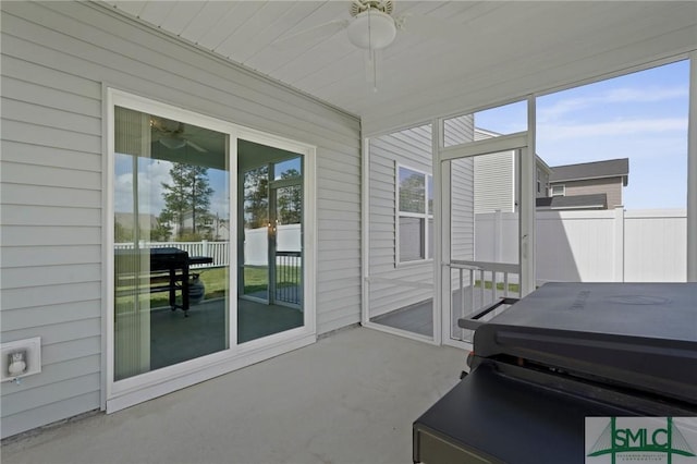 sunroom featuring a jacuzzi, a ceiling fan, and a healthy amount of sunlight